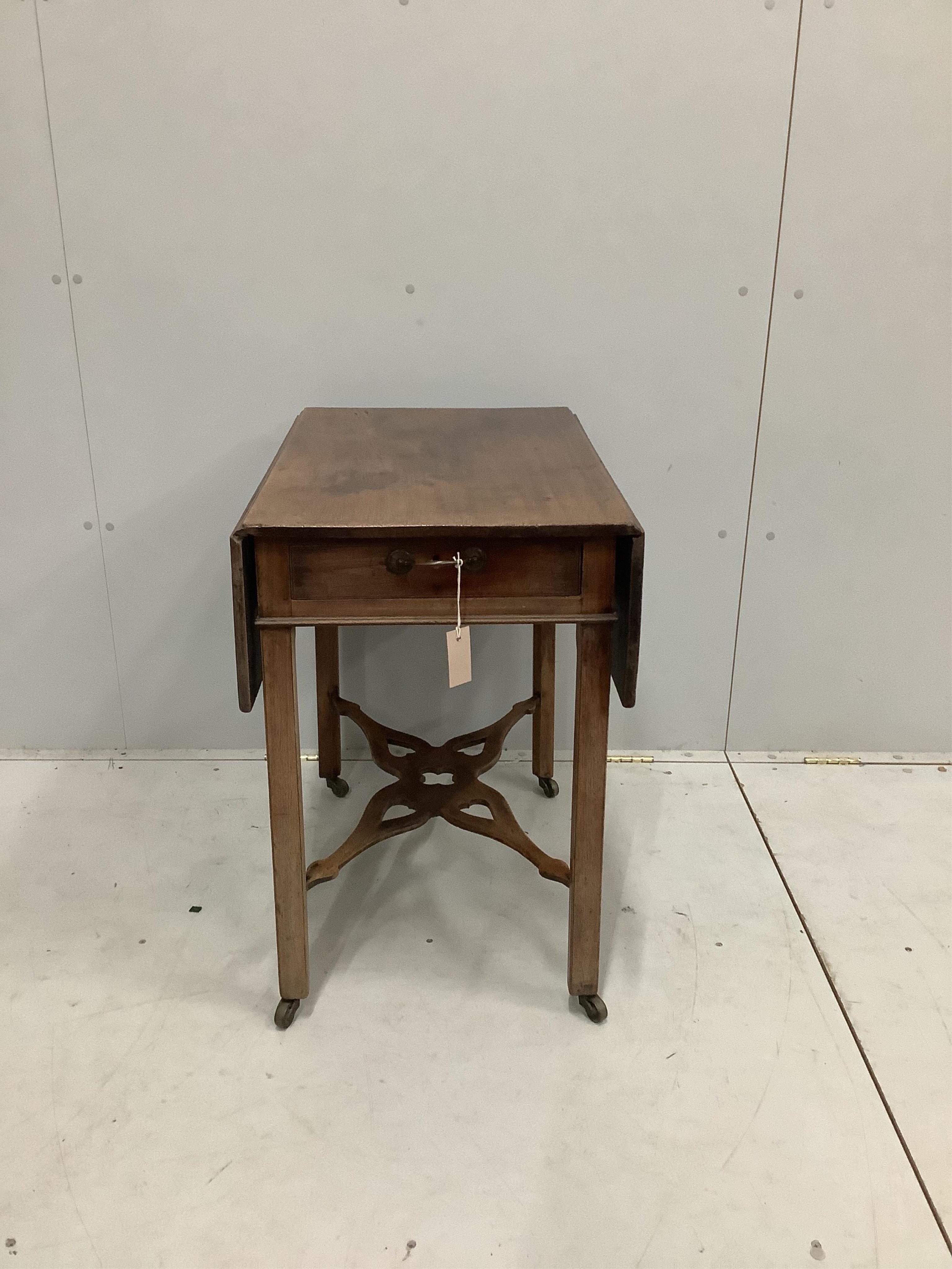 A George III mahogany Pembroke table, with shaped pierced cross stretcher, on chamfered legs with castors, width 47cm, depth 71cm, height 71cm. Condition - fair